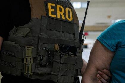 ERO agent holding an illegal immigrant's arm