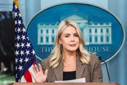 Karoline Leavitt speaking at the White House Press Room podium.