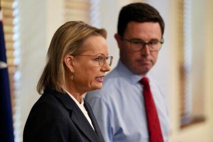 Woman in foreground and man looking towards her.
