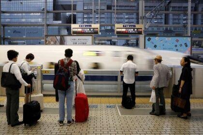 Passengers prepare to board a Shinkansen bullet train in Kyoto, Japan.