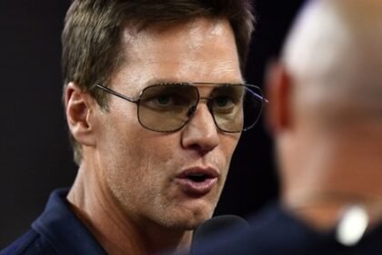 Aug 8, 2025; Foxborough, Massachusetts, USA; Retired Hall of Fame New England Patriot player Tom Brady talks with Brian Hoyer during the first half of a game against the Washington Commanders at Gillette Stadium. Mandatory Credit: Brian Fluharty-Imagn Images(IMAGN IMAGES via Reuters Connect)