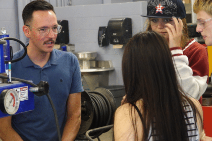 Trade school teacher talks with students