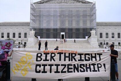 Protesters hold up birthright citizenship banner outside Supreme Court
