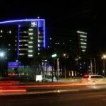 A photo of Phoenix Children's Hospital illuminated at night as cars drive by.