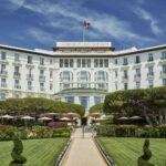 Image may contain Grass Plant Architecture Building Hotel City Lawn Flag Housing Office Building Resort and Fence