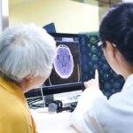 doctor points to MRI brain scan with patient