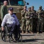 Gov. Abbott at the border with the National Guard standing behind him.