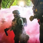 Police and federal officers throw gas canisters to disperse protesters near a US Immigration and Customs Enforcement facility in Portland, Oregon, on Sunday.