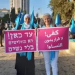 Women Wage Peace supporters carry a sign in Arabic and Hebrew that reads: “From now on, no one decides anything without women.”