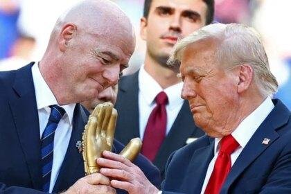 U.S. President Donald Trump looks at the golden glove trophy next to FIFA president Gianni Infantino after Chelsea won against Paris St Germain in the FIFA Club World Cup final